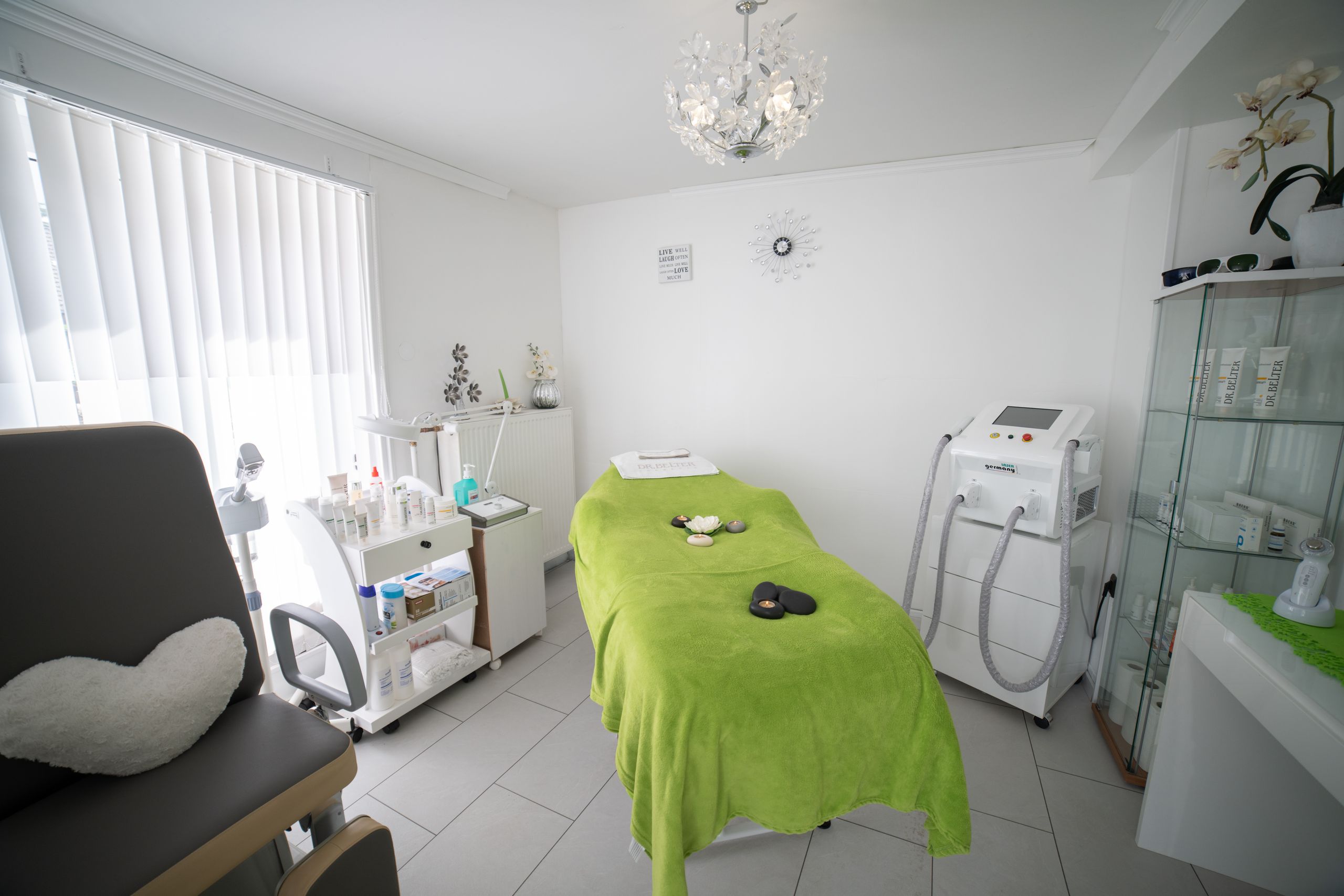 Interior of workplace of cosmetology clinic equipped with medical appliances with medicines and couch for massage